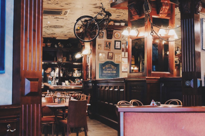 Panelled interior of a period bar with a ceiling grille above the bar, the kind of listed building where condensers have to be hidden